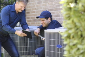 Multi ethnic team of blue collar air conditioner repairmen at work.